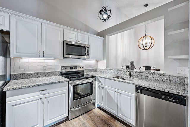 kitchen featuring white cabinetry, lofted ceiling, a chandelier, and stainless steel appliances