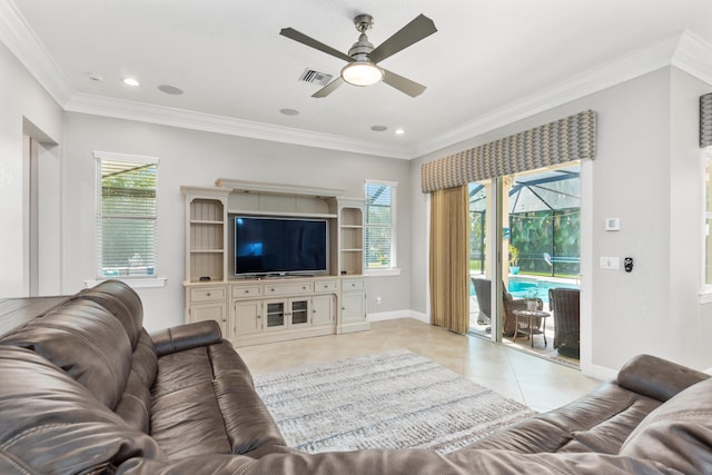 living room with ceiling fan, crown molding, light tile patterned floors, and a healthy amount of sunlight