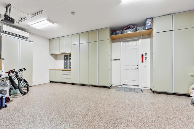 garage with a garage door opener and an AC wall unit