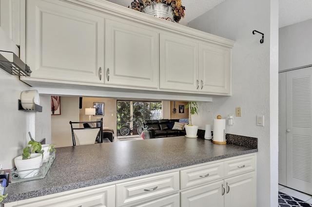 kitchen with dark countertops and white cabinets