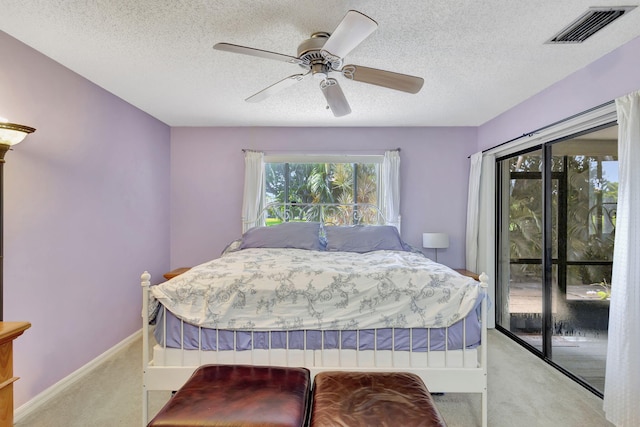 bedroom with access to exterior, visible vents, light carpet, a textured ceiling, and a ceiling fan