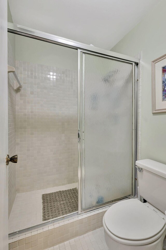 bathroom with toilet and a shower stall