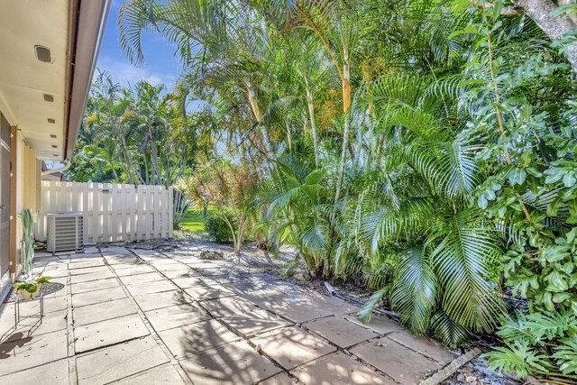 view of patio / terrace featuring central air condition unit and fence