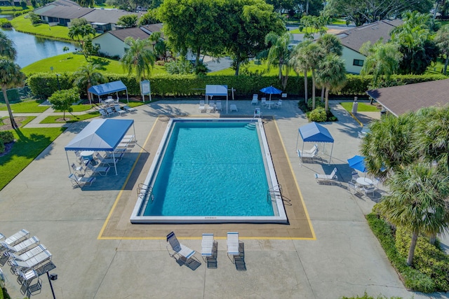 view of swimming pool featuring a patio area and a water view