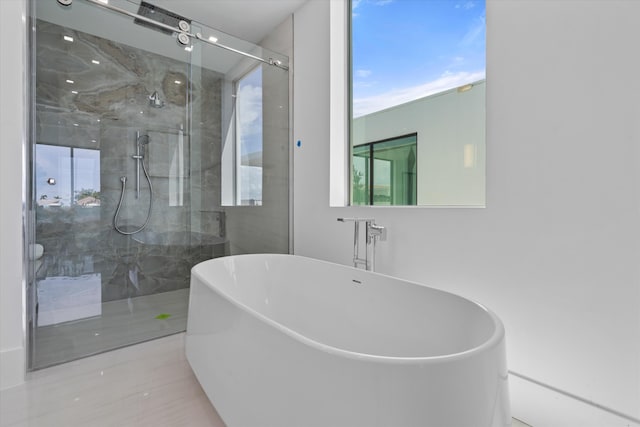 bathroom with separate shower and tub and a wealth of natural light