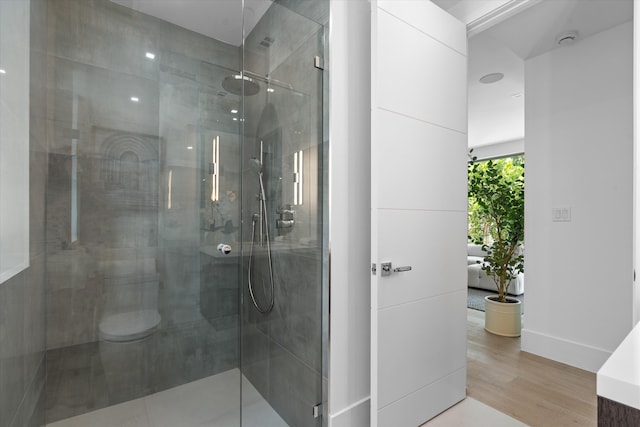 bathroom featuring hardwood / wood-style floors and a shower with door