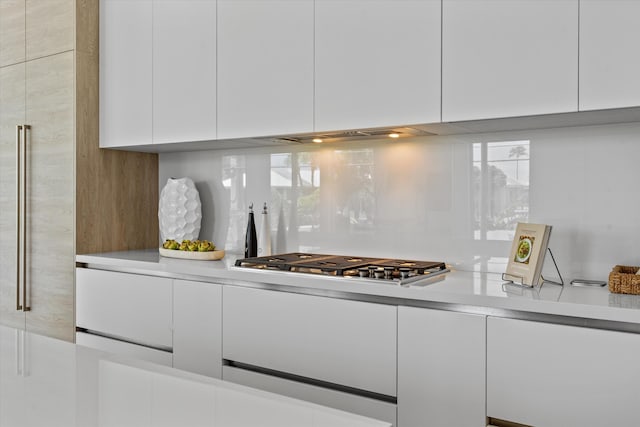 kitchen featuring white cabinets, backsplash, and stainless steel gas cooktop