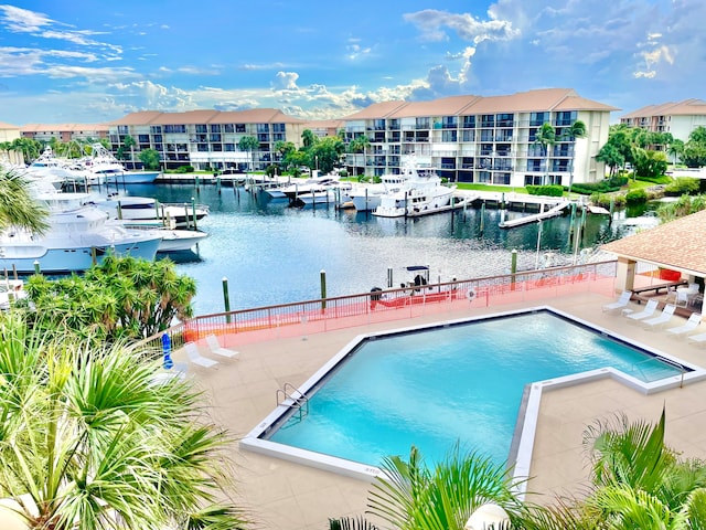 view of swimming pool featuring a water view and a patio