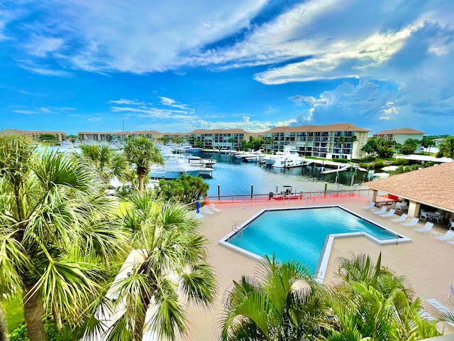 view of pool featuring a water view and a patio