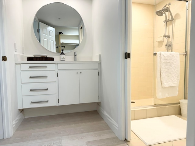 bathroom with a shower with door, vanity, and wood-type flooring