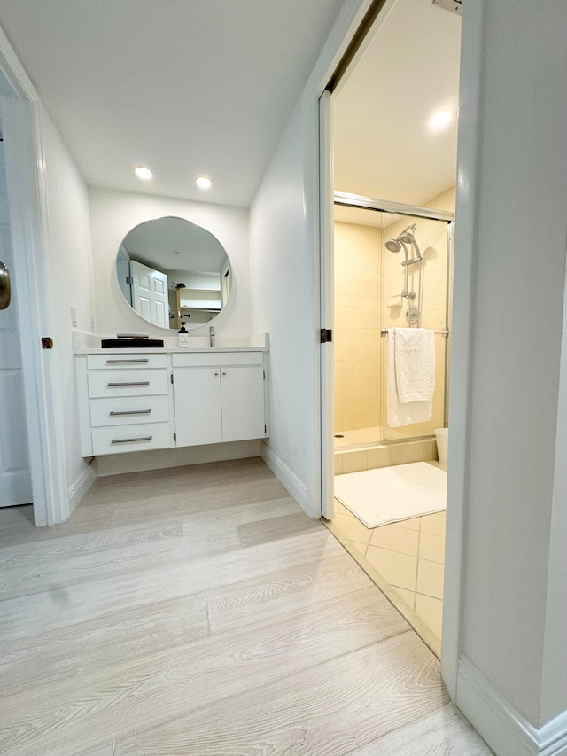 bathroom featuring a shower with door, wood-type flooring, and vanity