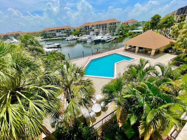 view of swimming pool with a patio area and a water view