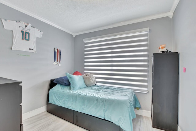 bedroom with a textured ceiling, crown molding, and light hardwood / wood-style flooring