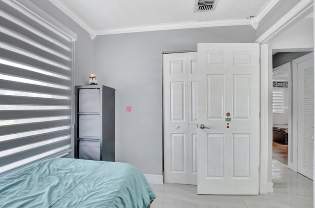 bedroom with a closet, ornamental molding, and a textured ceiling