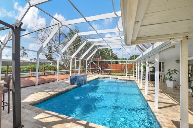 view of pool featuring glass enclosure, a patio area, and pool water feature