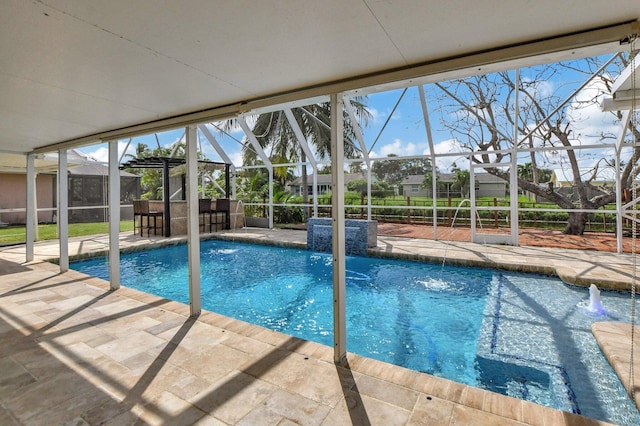 view of pool with a lanai, pool water feature, and a patio area