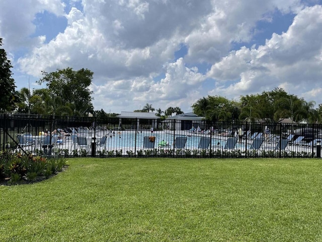 view of pool with a lawn