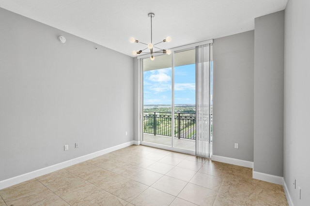 tiled spare room with expansive windows and a chandelier