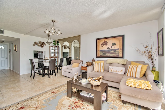 living room featuring visible vents, a notable chandelier, a textured ceiling, and light tile patterned floors