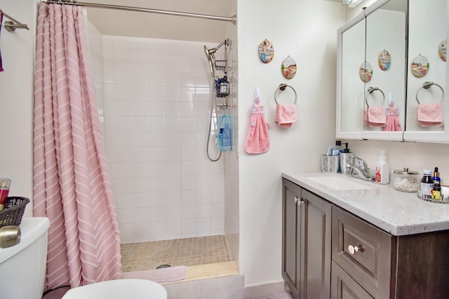 full bath with a stall shower, vanity, and toilet