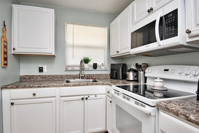 kitchen featuring white appliances, a sink, and white cabinets