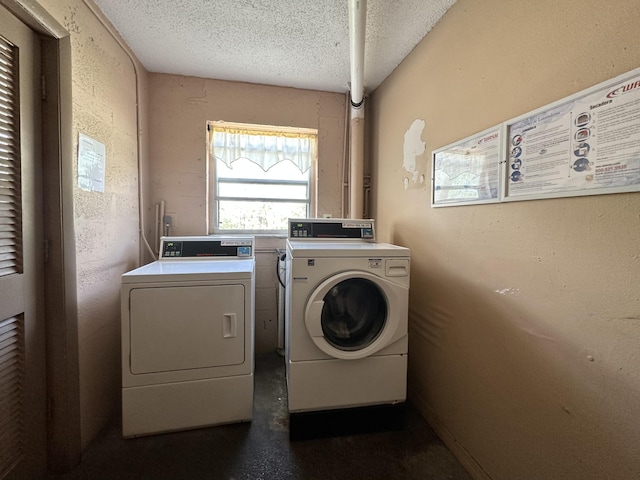 laundry area featuring a textured ceiling and washing machine and clothes dryer