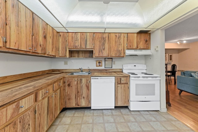 kitchen with white appliances, light hardwood / wood-style floors, a textured ceiling, and sink