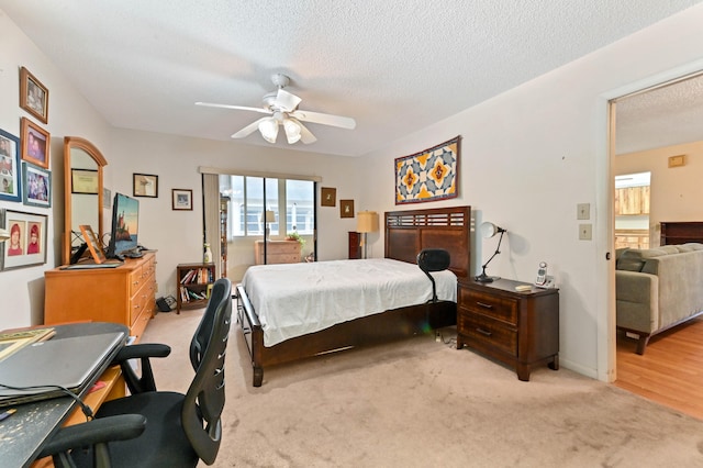 carpeted bedroom featuring a textured ceiling and ceiling fan