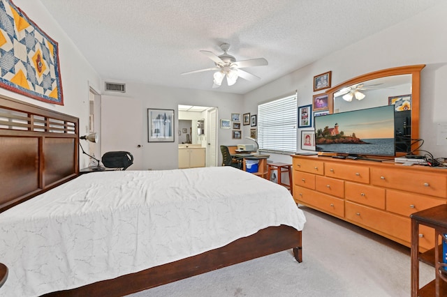 bedroom featuring carpet flooring, ceiling fan, ensuite bath, and a textured ceiling