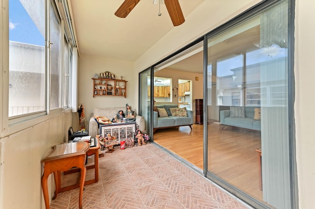 sunroom / solarium with ceiling fan and vaulted ceiling