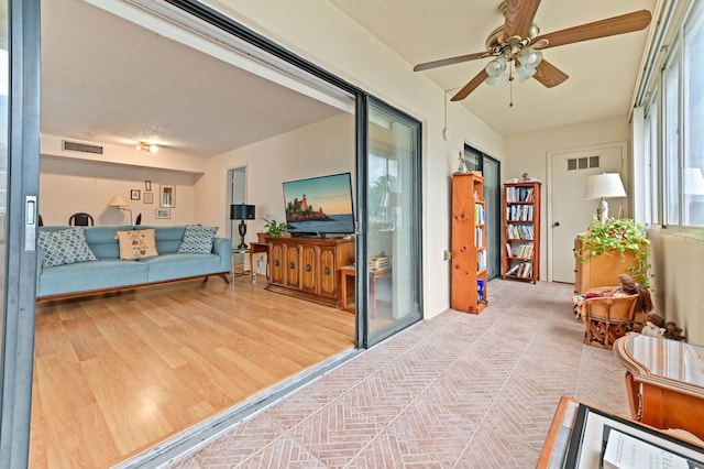 sunroom / solarium featuring ceiling fan