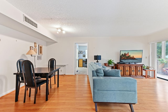 living room featuring light hardwood / wood-style floors and a textured ceiling