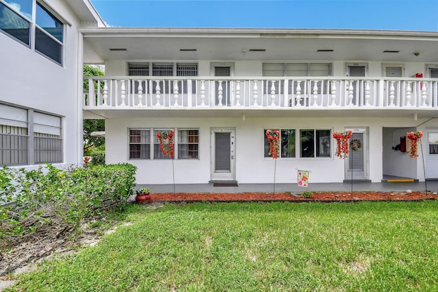 view of front of home with a front lawn and a balcony