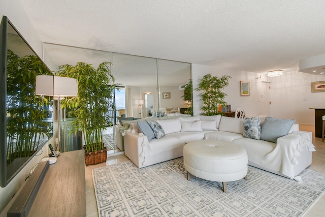 tiled living room featuring a textured ceiling