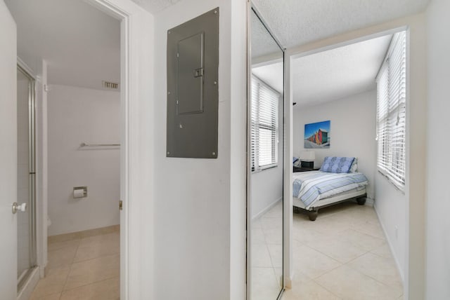 hallway featuring light tile patterned floors and electric panel