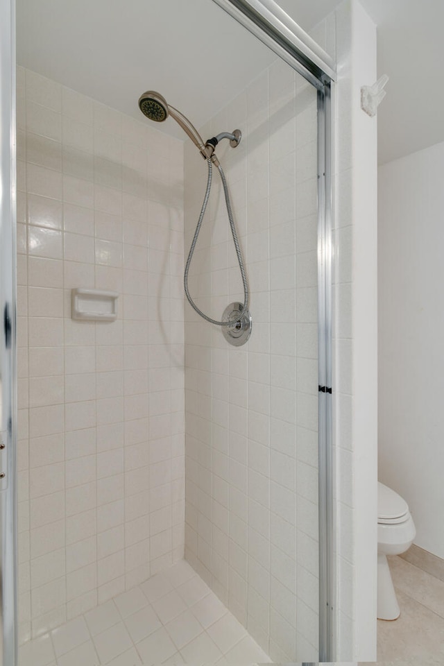 bathroom with tile patterned flooring, toilet, and walk in shower