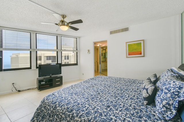 tiled bedroom featuring ceiling fan and a textured ceiling