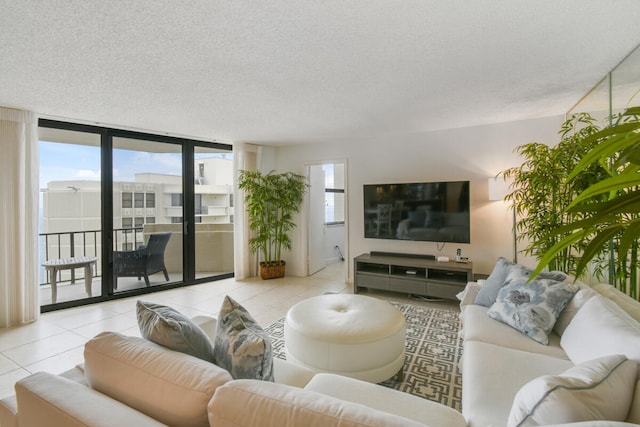 tiled living room featuring floor to ceiling windows and a textured ceiling