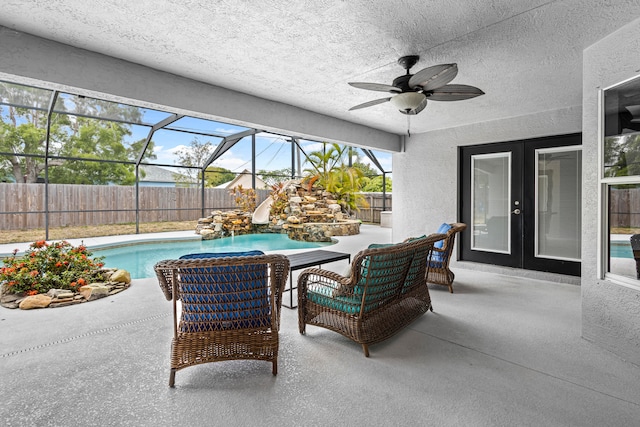 view of patio with glass enclosure, ceiling fan, and a fenced in pool