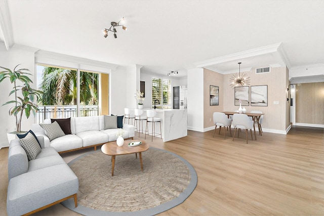 living room featuring crown molding, a healthy amount of sunlight, hardwood / wood-style floors, and sink