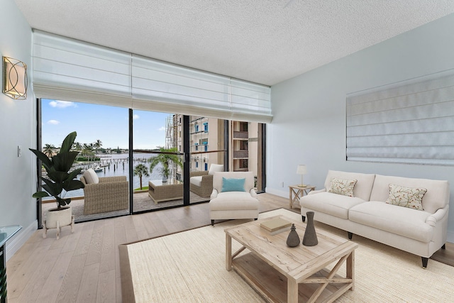 living room with light wood-type flooring and a textured ceiling