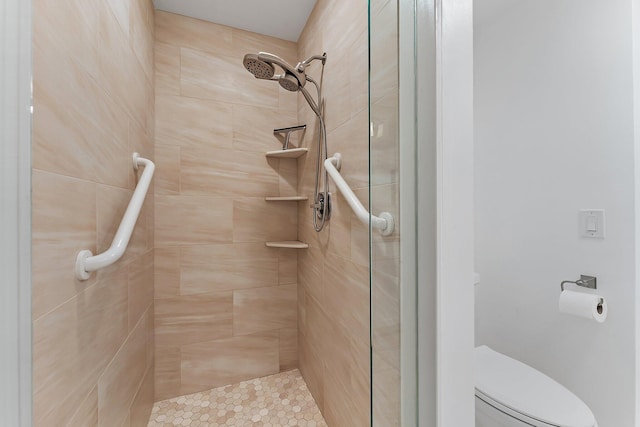 bathroom featuring tiled shower and toilet