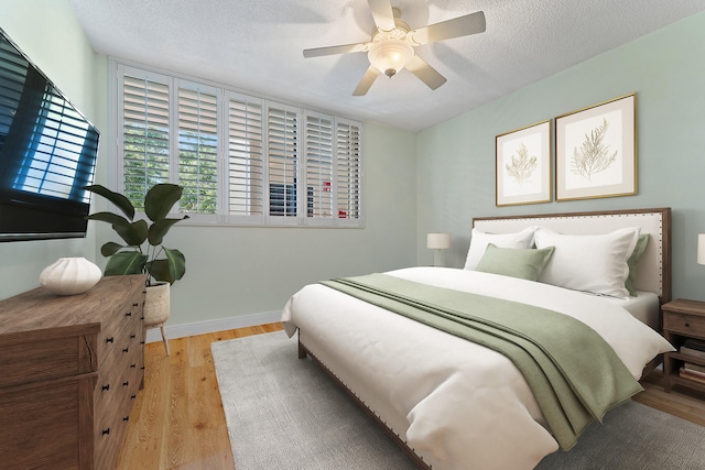 bedroom with light wood-type flooring, a textured ceiling, and ceiling fan