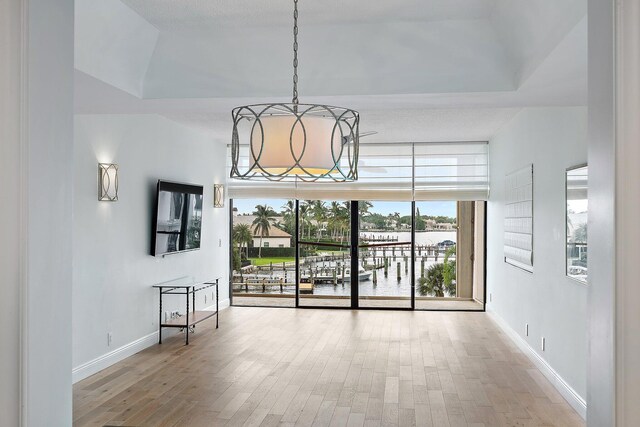 unfurnished dining area featuring an inviting chandelier and light hardwood / wood-style floors