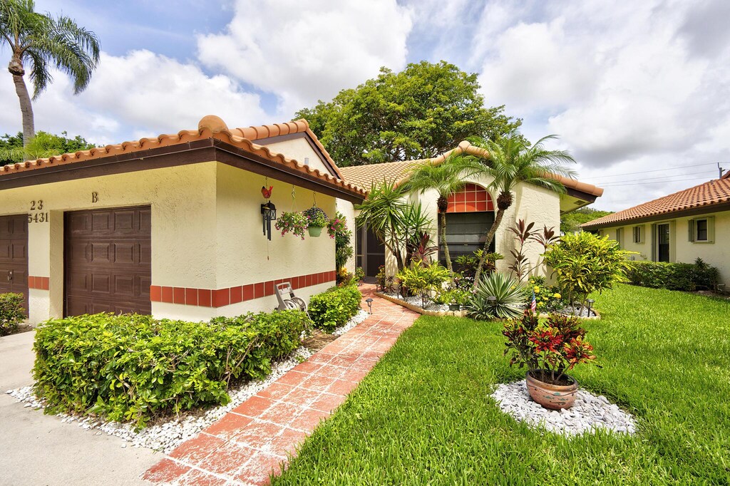 mediterranean / spanish home with a garage and a front lawn