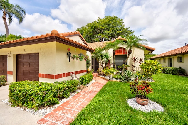 mediterranean / spanish home with a garage and a front lawn