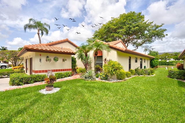 mediterranean / spanish-style house with a front yard