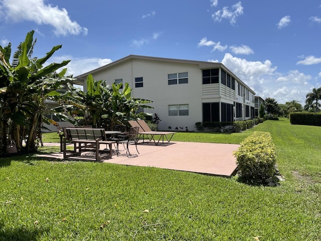 view of property's community featuring a yard and a patio