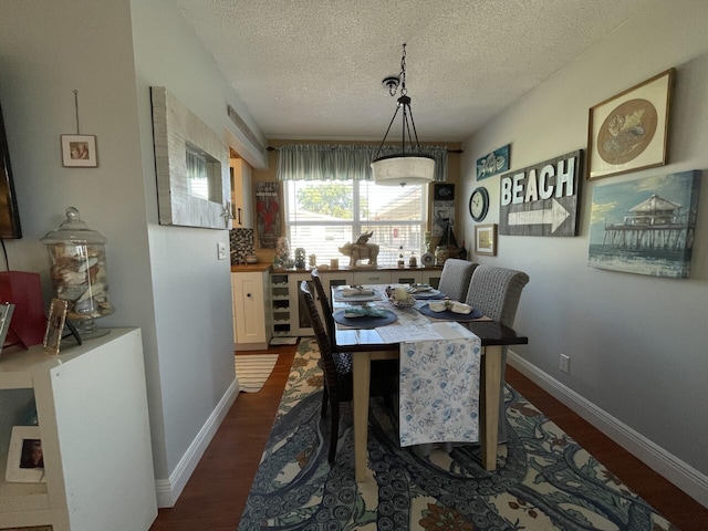 dining room with dark wood-type flooring and a textured ceiling