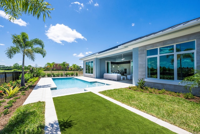 view of swimming pool featuring an outdoor living space, a lawn, and a patio area